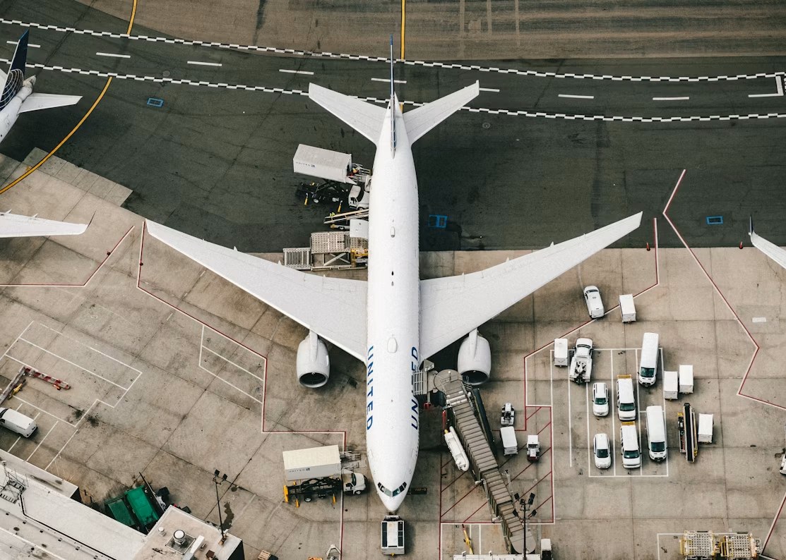 공항 주기장에 서 있는 여객기와 지상조업 차량을 위에서 내려다본 모습