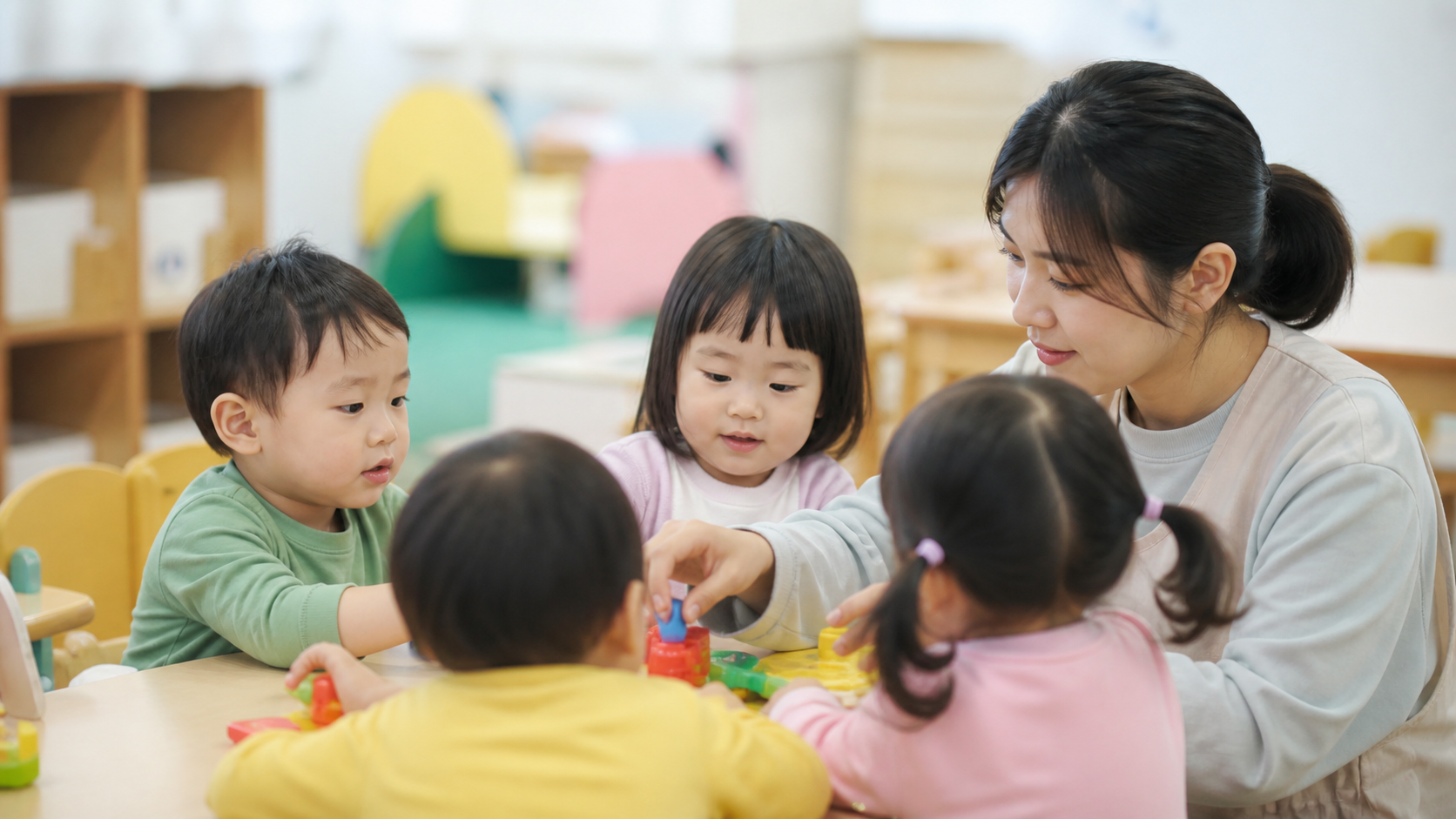 어린이집 교실에서 보육교사와 놀이 활동을 하는 영유아들