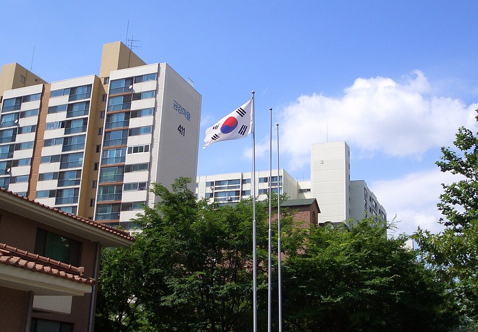 파란 하늘 아래 깃대에서 펄럭이는 태극기