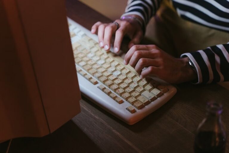 빈티지 베이지색 키보드로 문서를 입력하는 손
