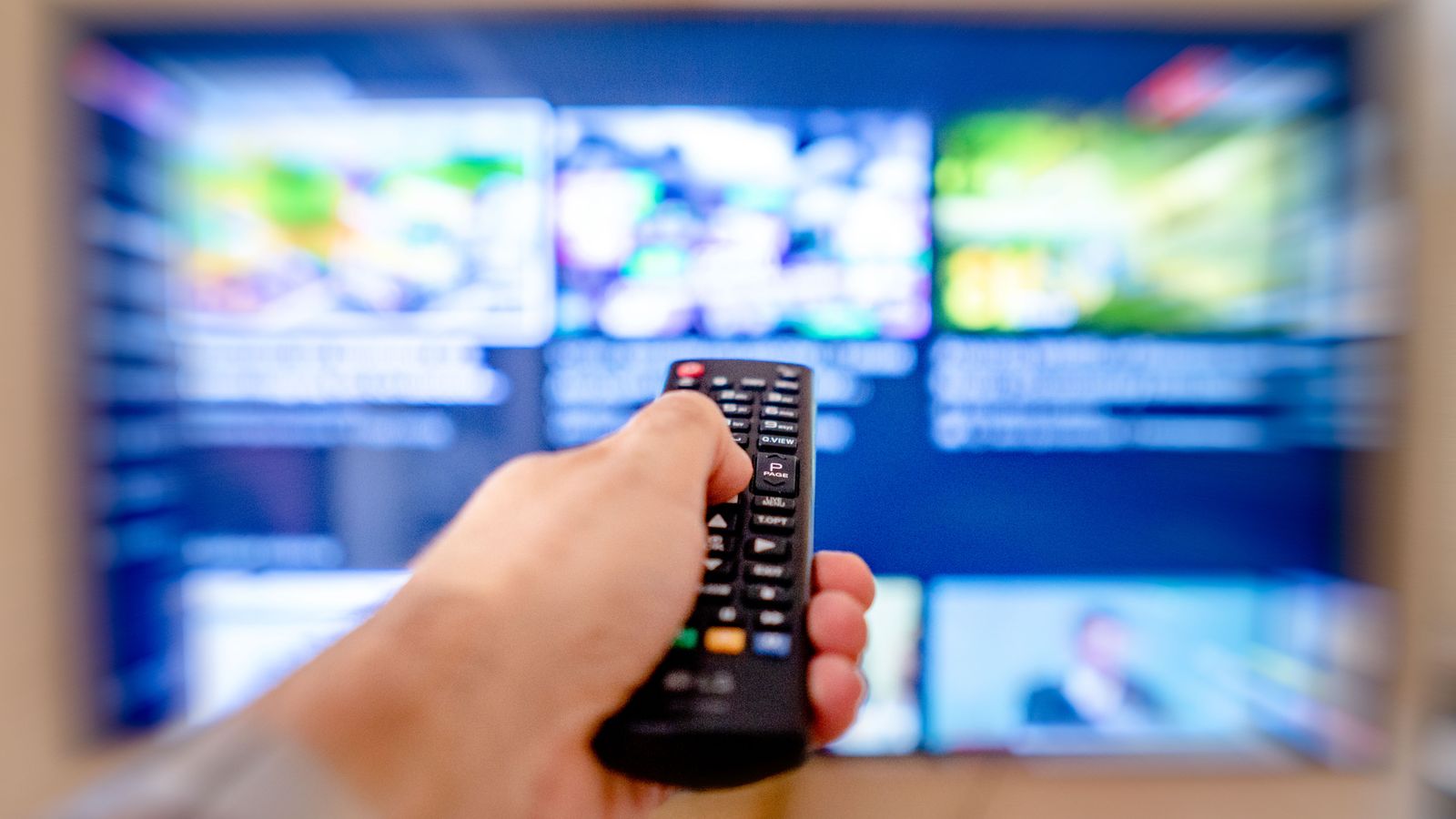 TV 화면을 향해 리모컨을 조작하는 손