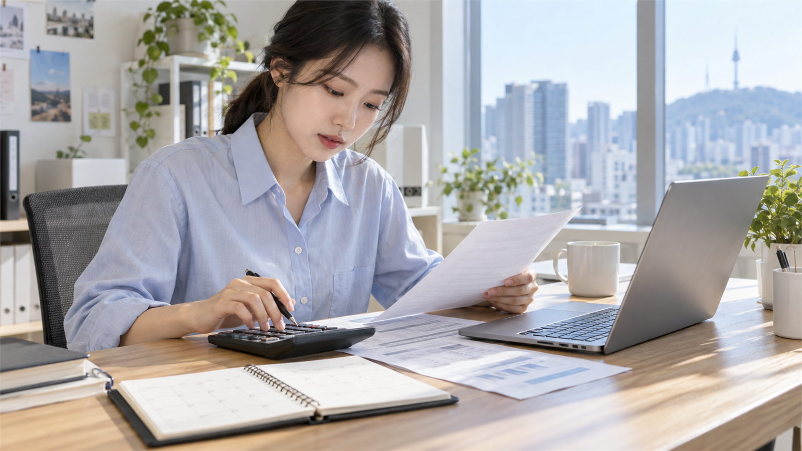 근로자가 노트북과 계산기로 월급을 계산하는 장면